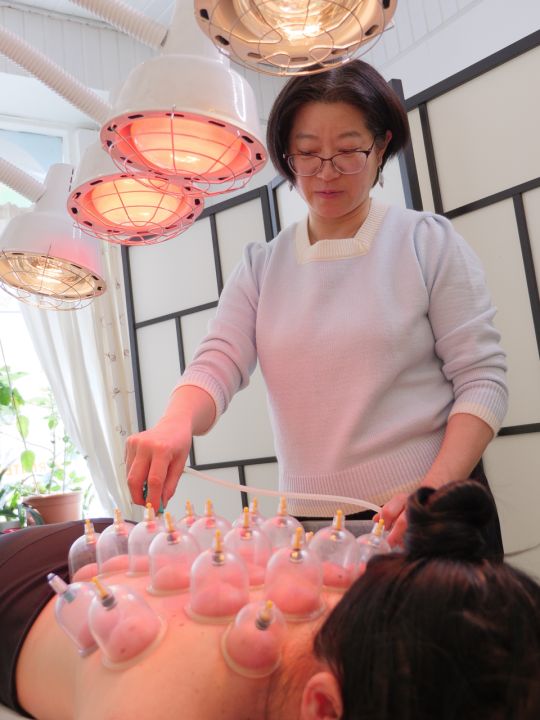 Kiinalainen l&auml;&auml;k&auml;ri tekee kuppausta