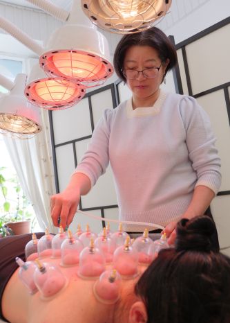 Kiinalainen lääkäri tekee kuppausta